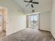 Bright bedroom featuring a ceiling fan, slider to the outside and neutral carpeting at 5705 N Genoa Way # 308, Aurora, CO 80019