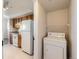 View of the kitchen with white appliances and wood cabinets. Laundry adjacent to the kitchen at 5705 N Genoa Way # 308, Aurora, CO 80019