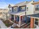 Attractive two-story home featuring a red front door and a covered porch, complemented by a landscaped front yard at 5074 Yosemite Ct # 1, Denver, CO 80238