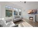 Bright living room with large windows, a cozy fireplace, and comfortable seating, perfect for relaxation at 5074 Yosemite Ct # 1, Denver, CO 80238