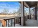 Inviting covered front porch with brick accents and a wooden railing offering views of the quiet residential street at 5074 Yosemite Ct # 1, Denver, CO 80238