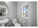 A well-lit powder room features a pedestal sink and a window for natural light at 5074 Yosemite Ct # 1, Denver, CO 80238