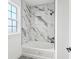 Stylish bathtub and shower adorned with marble tilework in this modern bathroom at 30355 E 161St Ave, Brighton, CO 80603
