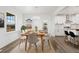 Sunlit dining room with an elegant table and views of the modern, white kitchen at 30355 E 161St Ave, Brighton, CO 80603