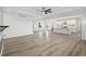 Open-concept living room flowing into the kitchen, with white walls and wood floors at 30355 E 161St Ave, Brighton, CO 80603