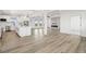 Open-concept living and kitchen area with wood flooring and natural light at 30355 E 161St Ave, Brighton, CO 80603