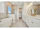 Bright bathroom features a soaking tub, glass shower, and double sink vanity at 5930 S Platte Canyon Dr, Littleton, CO 80123