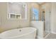 Bright bathroom includes a soaking tub with a separate tiled shower and exterior window at 5930 S Platte Canyon Dr, Littleton, CO 80123