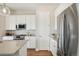 Modern kitchen showcasing stainless steel appliances, white cabinets, subway tile backsplash and wood-look flooring at 5930 S Platte Canyon Dr, Littleton, CO 80123