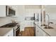 Gourmet kitchen with stainless steel appliances, island bar and gas range at 5930 S Platte Canyon Dr, Littleton, CO 80123