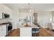 Well-lit kitchen with white cabinets, stainless steel appliances, large island with seating, and wood flooring at 5930 S Platte Canyon Dr, Littleton, CO 80123