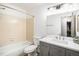 This full bathroom features a shower-tub combo, gray vanity, and modern fixtures at 8035 W Eastman Pl # 106, Lakewood, CO 80227