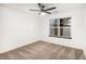 The bright bedroom features neutral carpet, a modern ceiling fan, and a large window at 8035 W Eastman Pl # 106, Lakewood, CO 80227