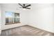 The airy bedroom features neutral carpet, a ceiling fan, and a large window at 8035 W Eastman Pl # 106, Lakewood, CO 80227