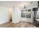 Open dining area features wood-look flooring, a modern chandelier, and a window for natural light at 8035 W Eastman Pl # 106, Lakewood, CO 80227