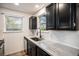 Stylish kitchen with sleek black cabinets, stainless steel sink and modern fixtures beneath a large window at 8035 W Eastman Pl # 106, Lakewood, CO 80227