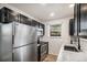 This kitchen boasts stainless steel appliances, black cabinets, and a large window over the sink at 8035 W Eastman Pl # 106, Lakewood, CO 80227