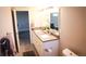Well-lit bathroom with double sinks, white cabinets, tile flooring, and a large mirror at 7100 Saulsbury St, Arvada, CO 80003