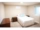 Cozy bedroom features neutral walls, carpet, a window and a comfortable bed dressed with blue pillows at 7100 Saulsbury St, Arvada, CO 80003