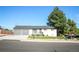 Well-maintained single-story house featuring a gray roof, attached garage, small porch, and beautiful tree at 7100 Saulsbury St, Arvada, CO 80003