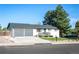 Well-maintained single-story house featuring a gray roof, attached garage, small porch, and beautiful tree at 7100 Saulsbury St, Arvada, CO 80003