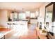 Open-concept living room with hardwood floors and updated kitchen with stainless steel appliances at 7100 Saulsbury St, Arvada, CO 80003