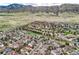Expansive aerial view of a vibrant neighborhood nestled against rolling hills, showcasing well-maintained homes and lush greenery at 9825 S Iris Ct, Littleton, CO 80127
