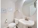 Powder room featuring a pedestal sink, round mirror, and elegant decorative touches at 9825 S Iris Ct, Littleton, CO 80127