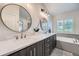 Luxurious bathroom with double vanity, soaking tub, glass-enclosed shower, and modern fixtures at 9825 S Iris Ct, Littleton, CO 80127