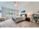 Comfortable bedroom with a ceiling fan, plush carpeting and ample natural light from a large window at 9825 S Iris Ct, Littleton, CO 80127