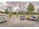 An outdoor deck with furniture, grill, and beautiful views of a green lawn and bare winter trees at 9825 S Iris Ct, Littleton, CO 80127