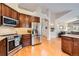 Stylish kitchen with stainless steel appliances, granite counters, and dark wood cabinets at 9825 S Iris Ct, Littleton, CO 80127