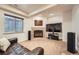 Basement living room features a stone fireplace, large TV, and comfortable seating, perfect for relaxation at 9825 S Iris Ct, Littleton, CO 80127