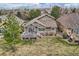 Backyard view featuring a stone facade, wooden deck, healthy lawn, and privacy trees, perfect for outdoor activities at 9825 S Iris Ct, Littleton, CO 80127