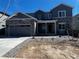 Charming two-story home featuring a stone facade, attached two-car garage, and well-manicured front yard with young landscaping at 2549 Lupton Ln, Lafayette, CO 80026