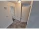 Hallway featuring neutral-toned tile flooring, white walls, and several doors and access to a staircase at 14190 E Gunnison Pl, Aurora, CO 80012
