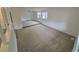 Bright living room with neutral carpet, white walls, large windows that offer ample natural light, and a step-up area at 14190 E Gunnison Pl, Aurora, CO 80012