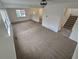 Open living room with neutral carpet, white walls, a staircase, and a window offering natural light at 14190 E Gunnison Pl, Aurora, CO 80012