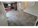 Spacious living space with dark cabinetry, stainless steel appliances, neutral-toned tile flooring, and a staircase at 14190 E Gunnison Pl, Aurora, CO 80012