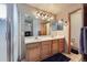 Bathroom featuring double vanity, a walk-in shower and updated lighting at 11218 Newark Ct, Commerce City, CO 80640