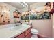Bathroom with sunflower decor, wood cabinets, and bright lighting at 11218 Newark Ct, Commerce City, CO 80640