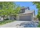 Two-story home with stone and siding exterior, gray garage door, and meticulously landscaped yard with rock accents at 11218 Newark Ct, Commerce City, CO 80640