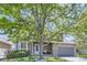 Charming two-story home with a stone facade and well-maintained front yard and large tree providing shade at 11218 Newark Ct, Commerce City, CO 80640