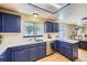 Well-lit kitchen with blue cabinetry, stainless steel appliances, and a convenient layout for efficient cooking at 11218 Newark Ct, Commerce City, CO 80640