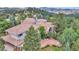 Aerial view of an estate home with tile roof, terraces and lush surroundings at 28 Indian Paintbrush Dr, Golden, CO 80401