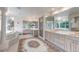 Bathroom with a standalone tub, dual vanities, marble accents, and a decorative rug at 28 Indian Paintbrush Dr, Golden, CO 80401