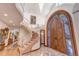 Grand foyer featuring a curved staircase, carved wood doors, and marble flooring at 28 Indian Paintbrush Dr, Golden, CO 80401