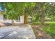 Large backyard patio shaded by a mature tree, brick wall with a chimney, and a covered patio area at 4365 Kendall St, Wheat Ridge, CO 80033
