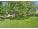 Lush backyard featuring a patio area, large tree, green grass and a building with slider doors for indoor/outdoor living at 4365 Kendall St, Wheat Ridge, CO 80033