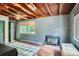 Living room with wood plank ceiling, brick accent wall and wood burning stove fireplace at 4365 Kendall St, Wheat Ridge, CO 80033